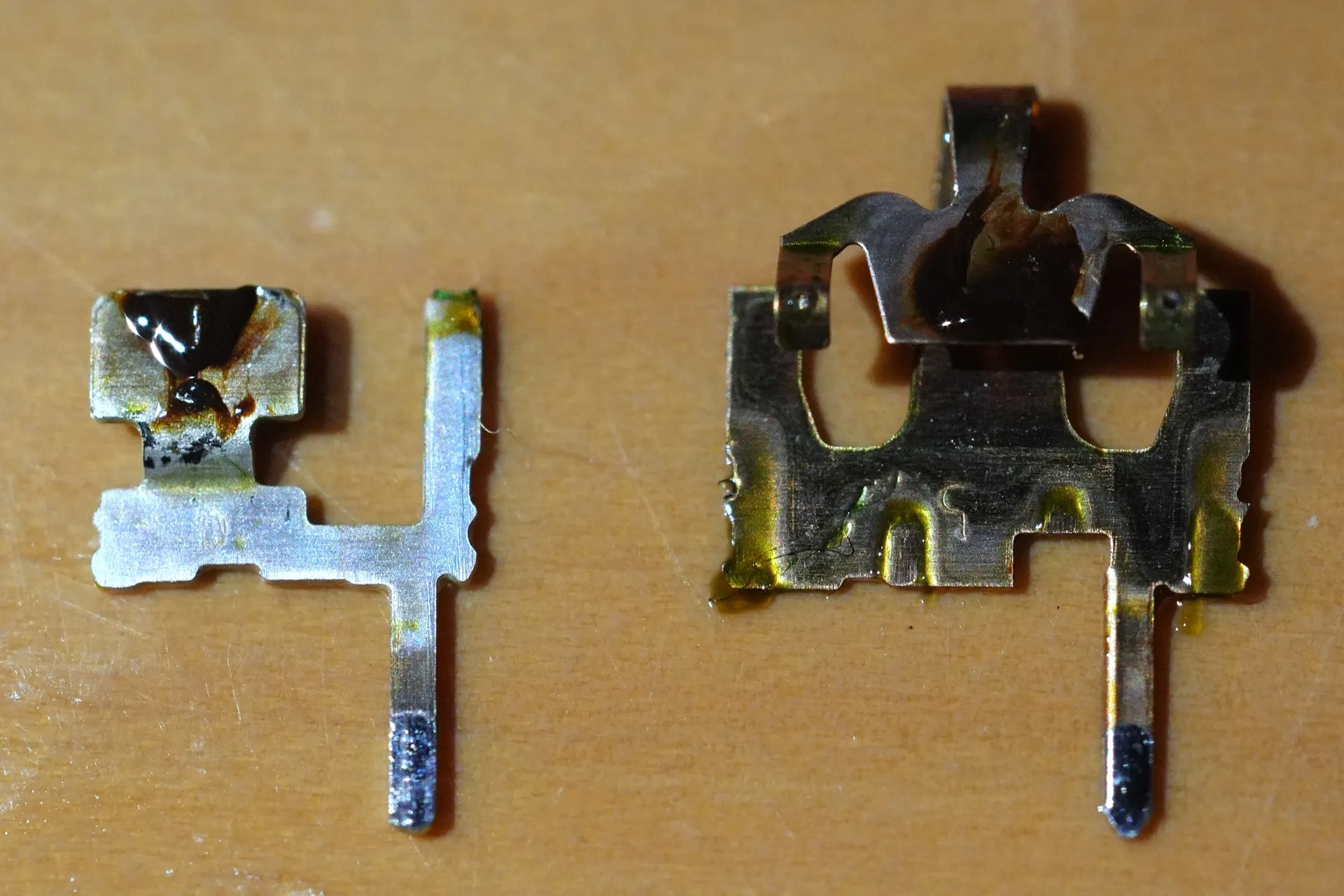 2つの金属部品がある。接点の周りには黒い物体が付着している。それ以外にも黄色っぽい液体が付着している部分がある。