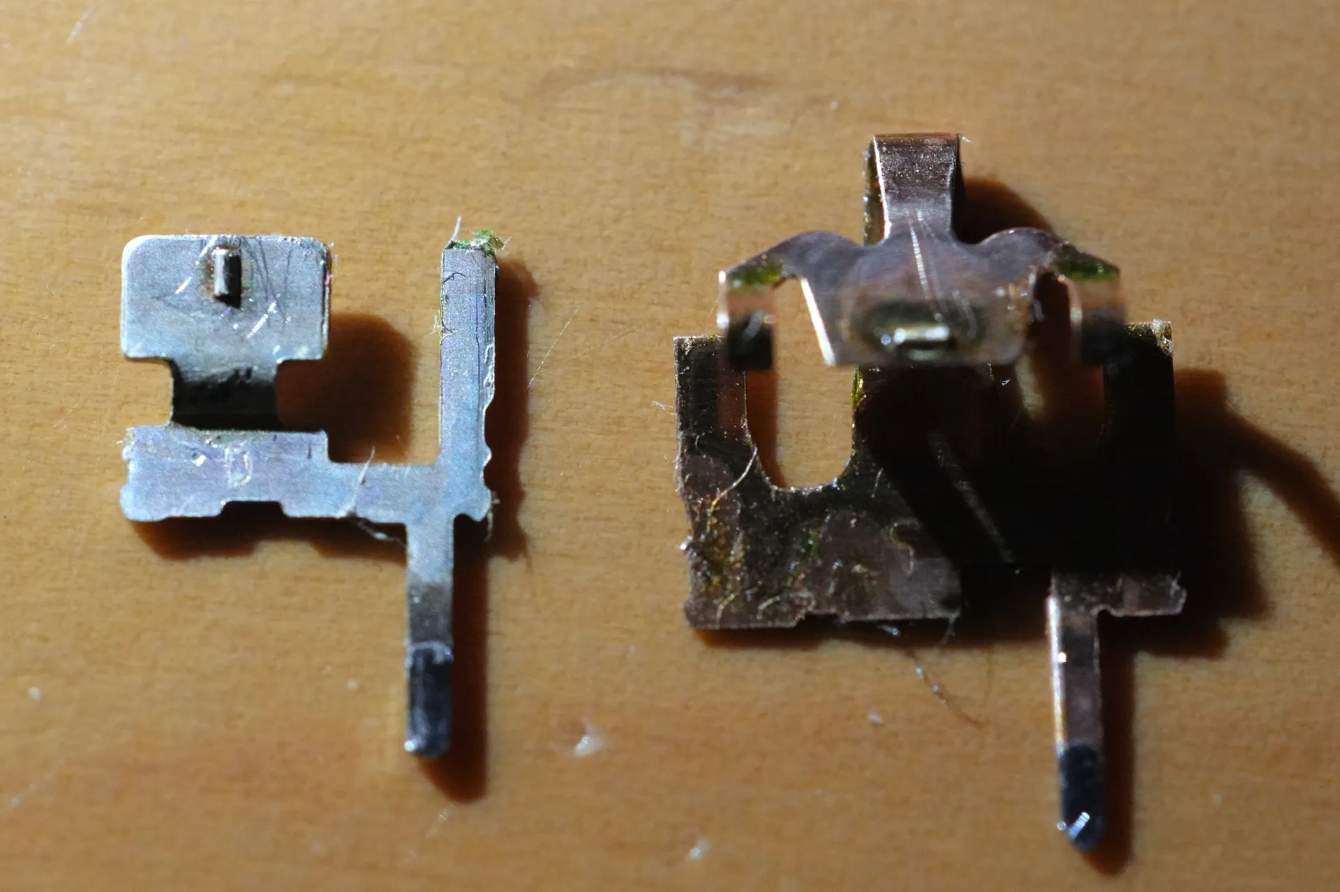 2つの金属部品がある。清掃前に付着していた汚れは取り除かれている。ティッシュの繊維が若干付着している。